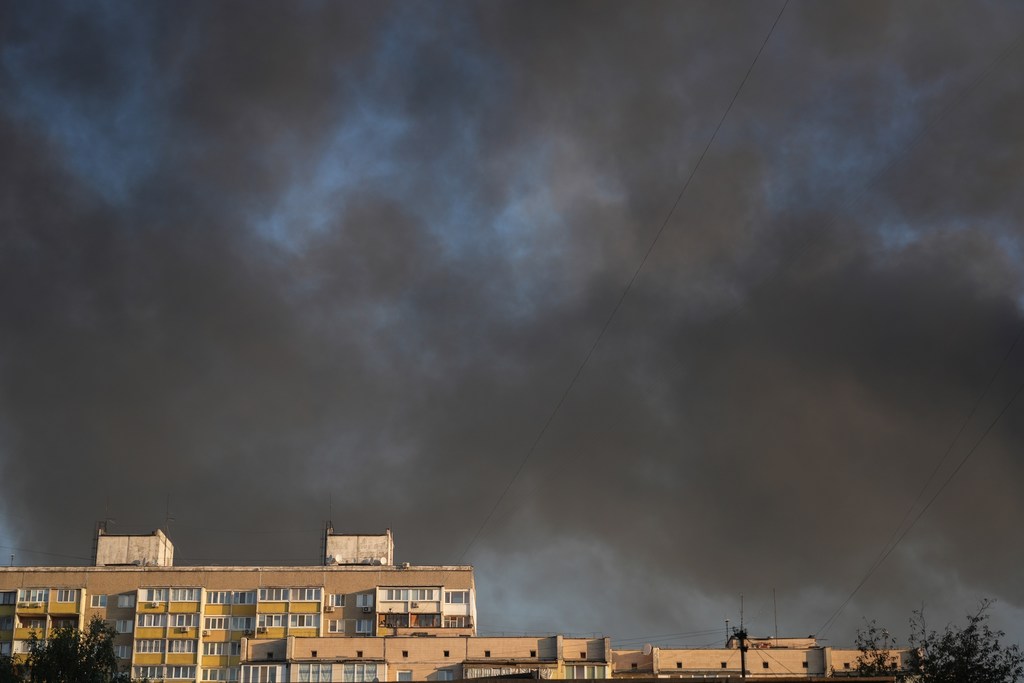 Une épaisse fumée noire remplit le ciel au-dessus d'immeubles résidentiels de Kiev après qu'une frappe de drone a mis le feu à un immeuble de neuf étages dans le quartier.